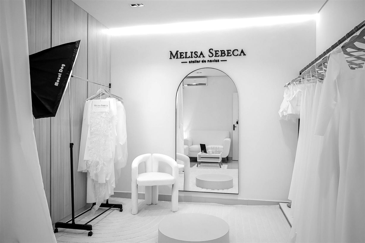 Salón del Atelier Melisa Sebeca, con vestidos y espejo