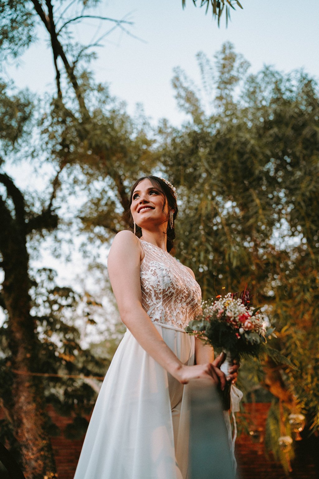 Novia sonriente en jardín, esencia del atelier